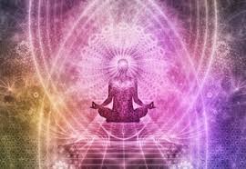 A person sits cross-legged on stairs in a yoga pose and is surrounded by purple, yellow, green and blue light radiating from their head.
