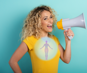 A woman in a yellow t-shirt with blond curly hair stands facing sideways with a mega phone in her hand and her mouth open and smiling as if she is happy with her self-expression. She has a glowing circle across her chest with a silhouette of a person holding out their arms inside.